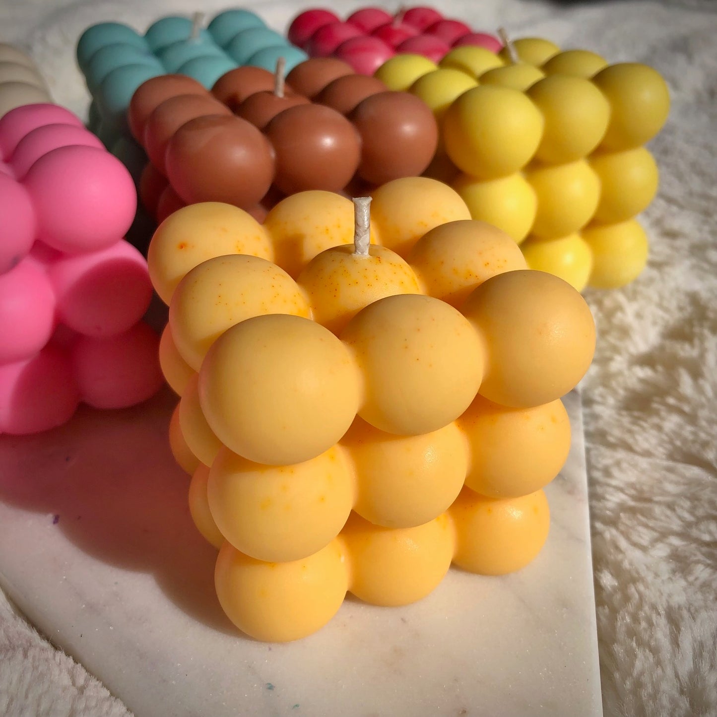 Light orange bubble candle on marble with our coloured bubble candles
