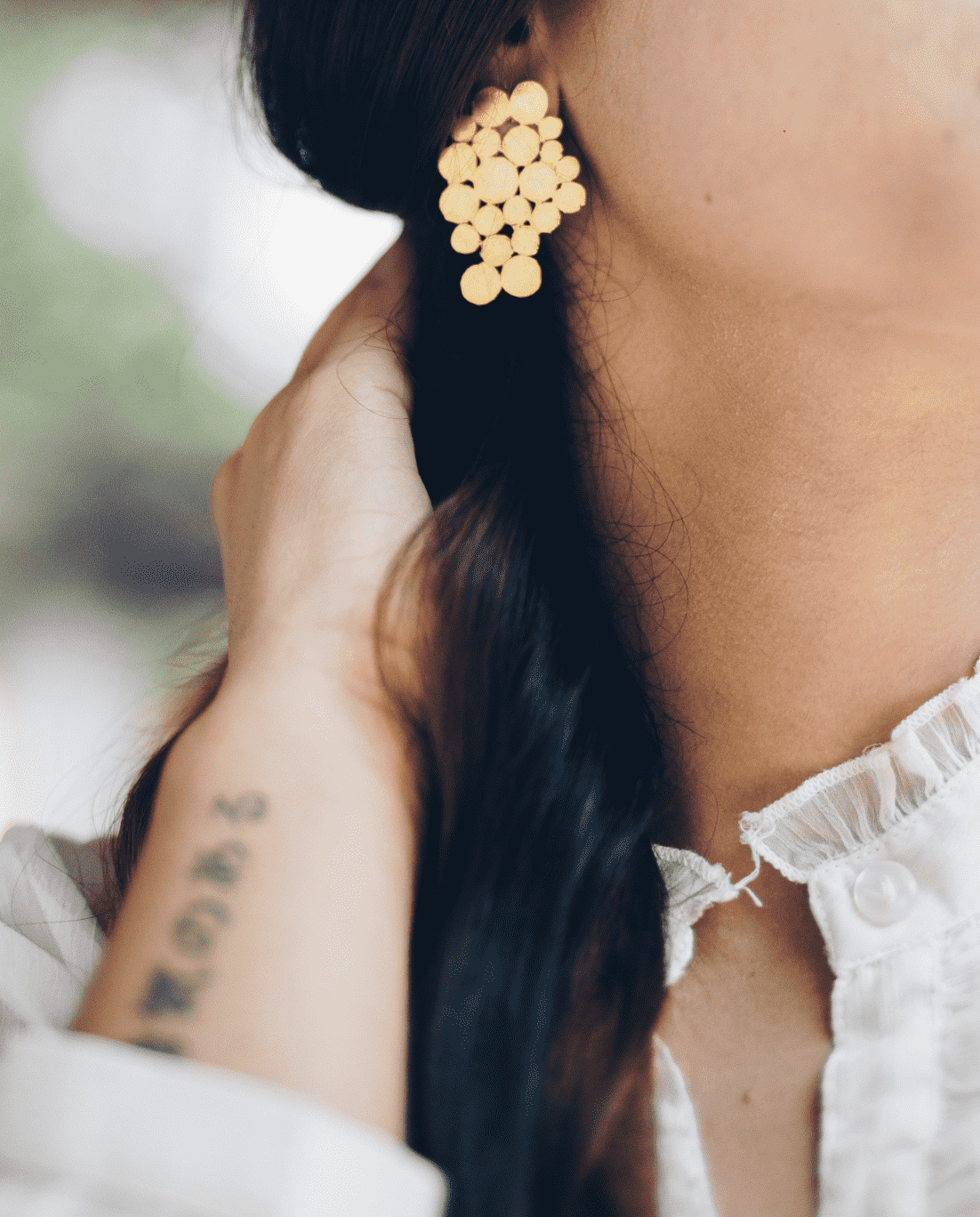 Gold dot colourd earring on model with long brown hair